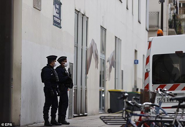 French police officers stand guard in front of the former Charlie Hebdo offices, on Rue Nicolas Appert in Paris today